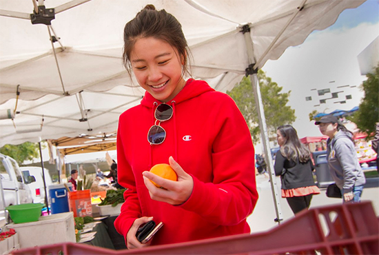 Student looking at produce at farmer's market